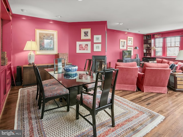 dining area with wood finished floors and crown molding