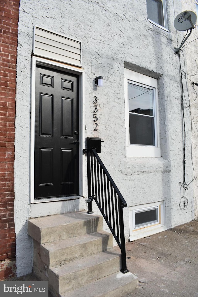 property entrance with stucco siding