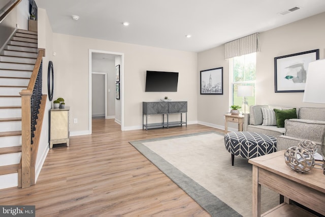 living room featuring visible vents, recessed lighting, light wood-type flooring, and stairs