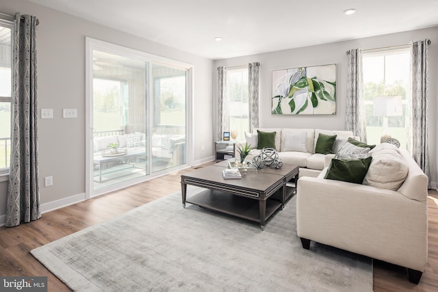 living room featuring recessed lighting, baseboards, and wood finished floors