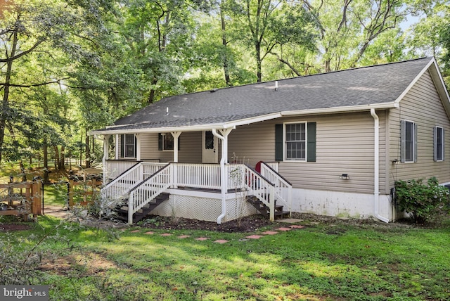 view of front of house featuring a shingled roof and a front lawn