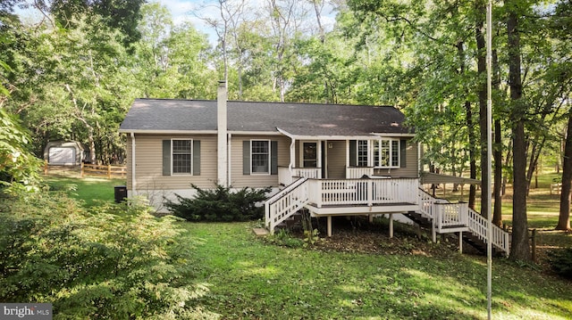 back of house with roof with shingles, a chimney, a lawn, stairway, and a deck