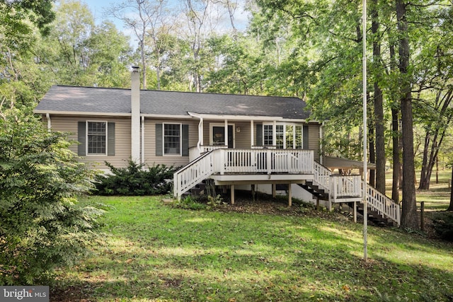 ranch-style home featuring roof with shingles, stairway, and a front yard