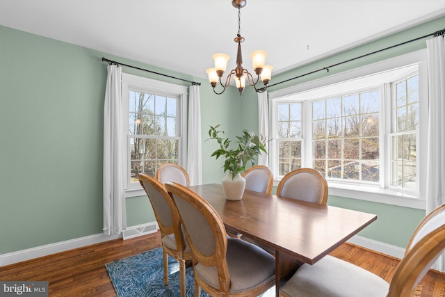 dining space featuring visible vents, wood finished floors, baseboards, and a chandelier