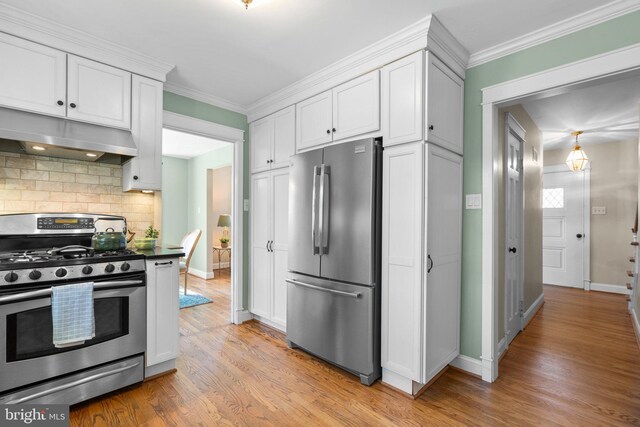 kitchen with light wood-style flooring, under cabinet range hood, tasteful backsplash, stainless steel appliances, and white cabinets