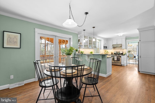 dining area with visible vents, baseboards, ornamental molding, french doors, and wood finished floors