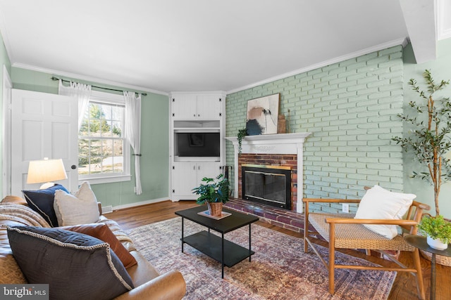 living room with baseboards, a brick fireplace, wood finished floors, and crown molding