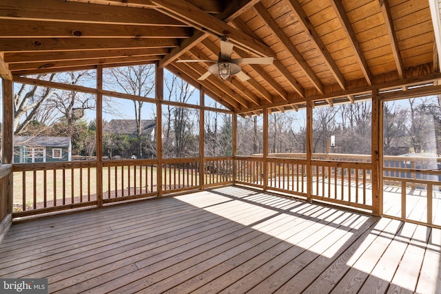 unfurnished sunroom with lofted ceiling, plenty of natural light, and a ceiling fan