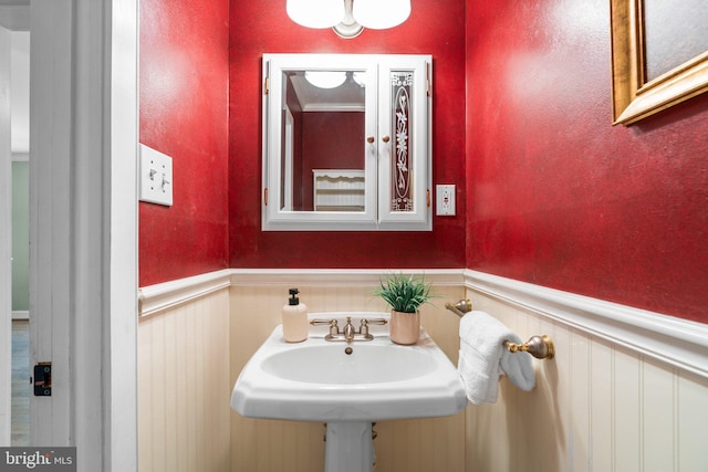 bathroom with a wainscoted wall and a sink