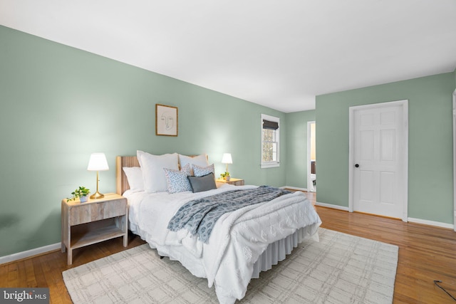 bedroom with baseboards and wood finished floors