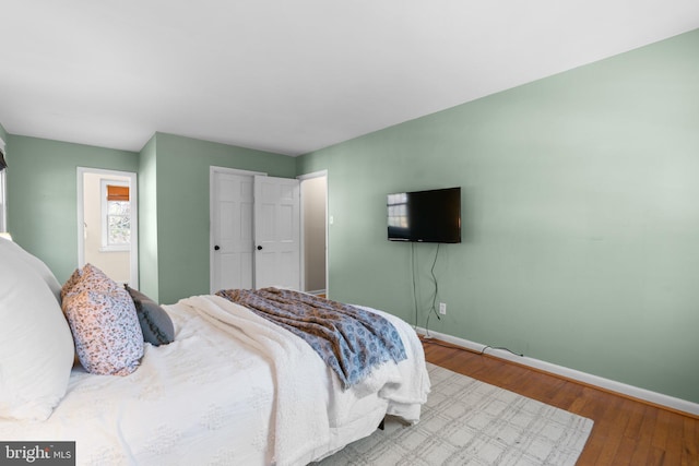 bedroom featuring baseboards and wood finished floors