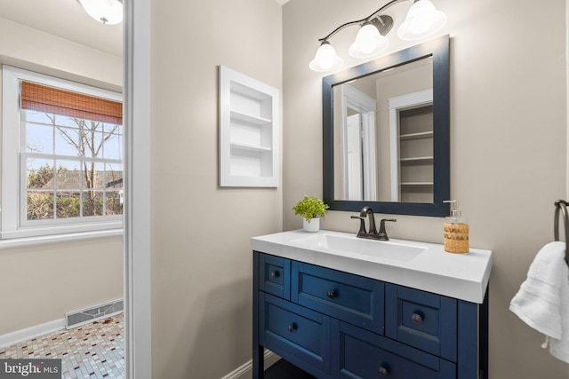 bathroom with visible vents, vanity, baseboards, and built in features