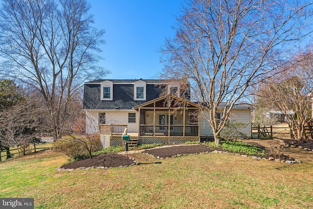 rear view of property featuring a lawn, fence, and roof with shingles