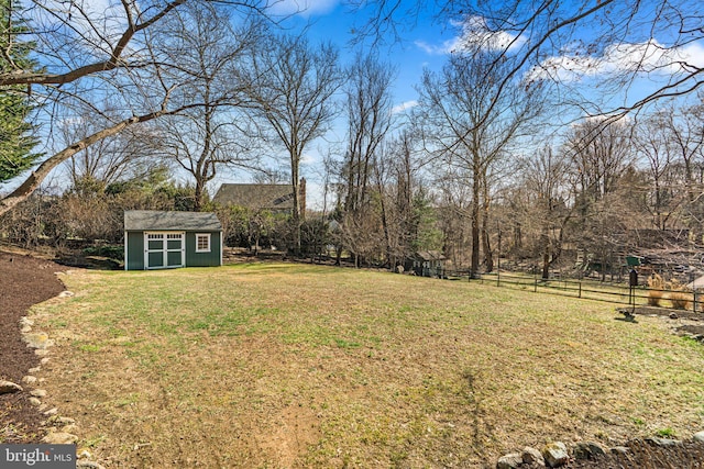 view of yard featuring a storage shed, an outbuilding, and fence