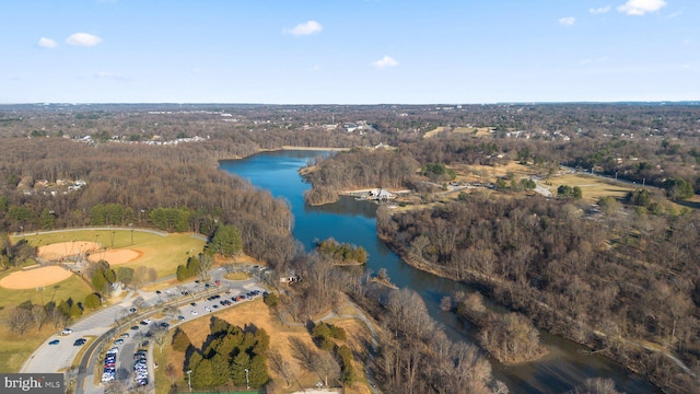 birds eye view of property featuring a forest view and a water view