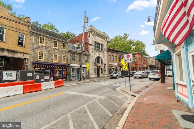 view of street with traffic signs, curbs, sidewalks, and street lighting