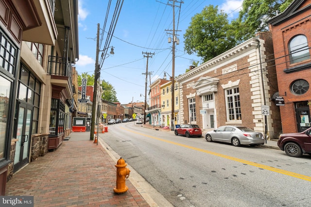 view of street with sidewalks, curbs, and street lights