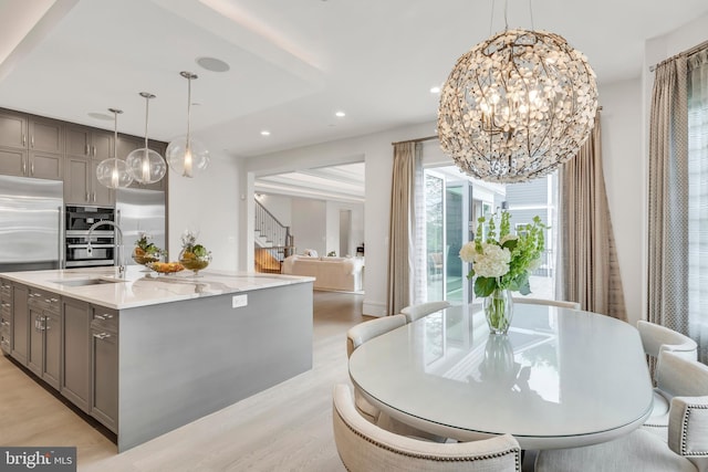 dining room featuring stairway, recessed lighting, light wood-style flooring, and an inviting chandelier