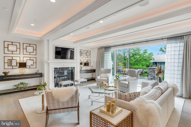 living room with a glass covered fireplace, beamed ceiling, recessed lighting, and wood finished floors