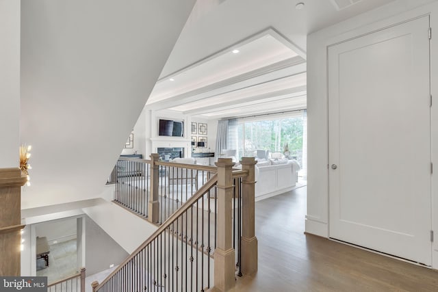 hallway with recessed lighting, an upstairs landing, and wood finished floors