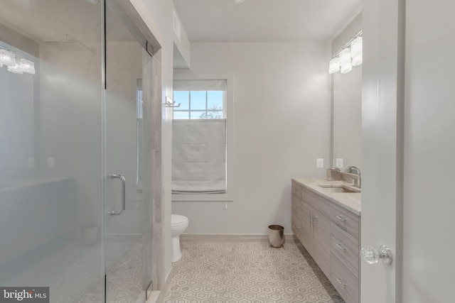 bathroom with a stall shower, baseboards, vanity, and toilet