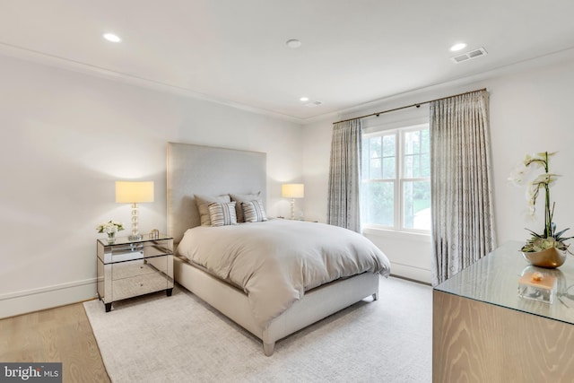 bedroom with light wood finished floors, recessed lighting, visible vents, ornamental molding, and baseboards