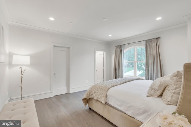 bedroom with ornamental molding, recessed lighting, and wood finished floors