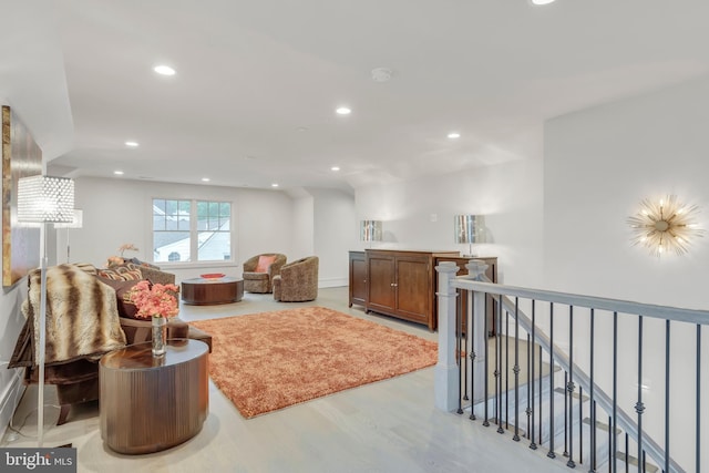 living area with light wood finished floors, an upstairs landing, and recessed lighting