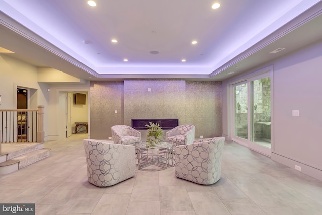 sitting room featuring an accent wall, a tray ceiling, and recessed lighting