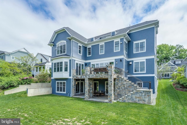 rear view of house featuring stone siding, a patio area, a lawn, and stairs