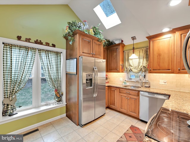 kitchen featuring light tile patterned floors, visible vents, lofted ceiling with skylight, appliances with stainless steel finishes, and a sink