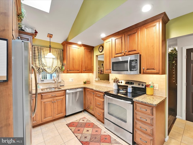 kitchen featuring light tile patterned floors, stainless steel appliances, light stone counters, and vaulted ceiling with skylight