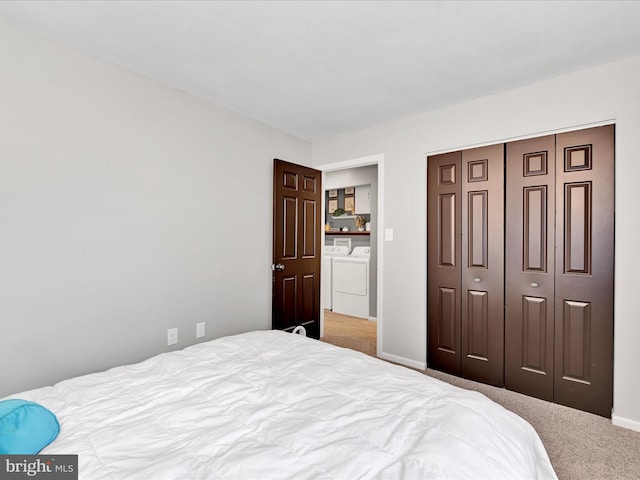 carpeted bedroom featuring baseboards, a closet, and independent washer and dryer