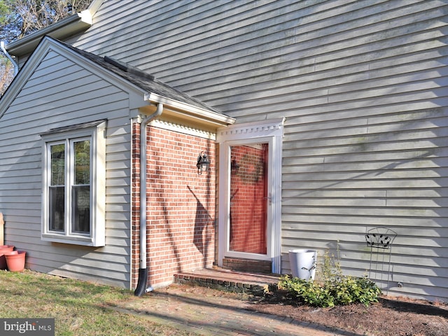 doorway to property featuring brick siding