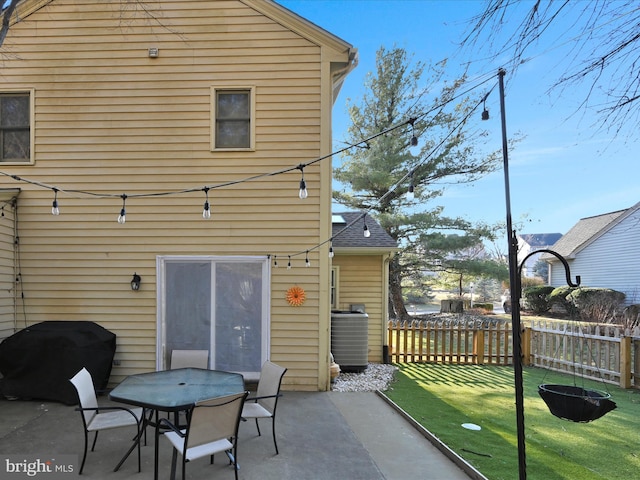 back of property featuring central AC, a patio, a lawn, and fence