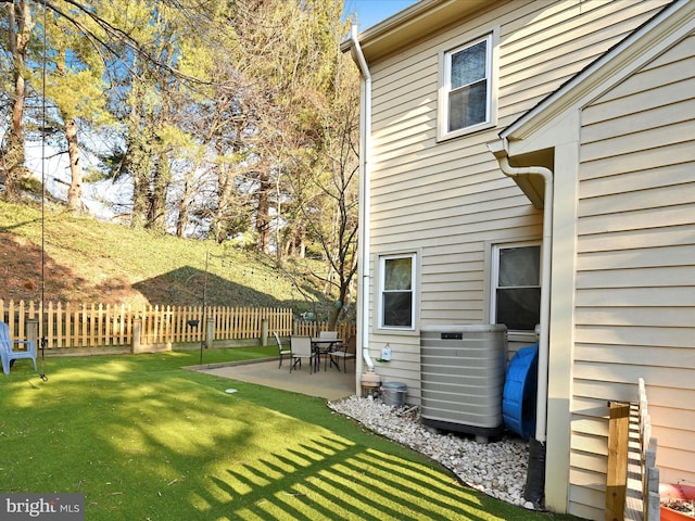 view of yard featuring central AC unit, a patio area, and fence