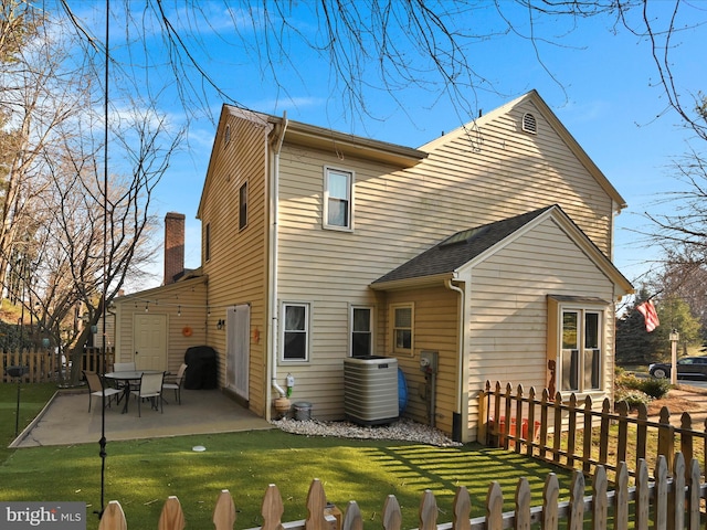 rear view of house with fence private yard, a patio area, and a yard