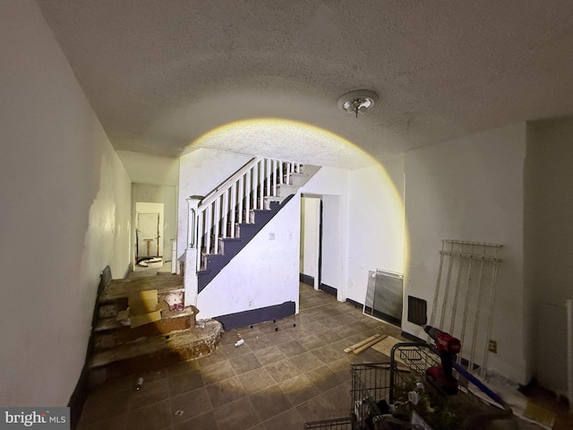 living room featuring stairs and a textured ceiling