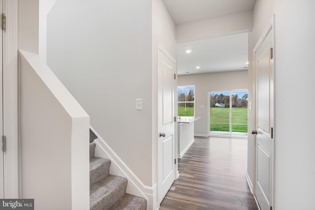 hall with stairs, baseboards, wood finished floors, and recessed lighting