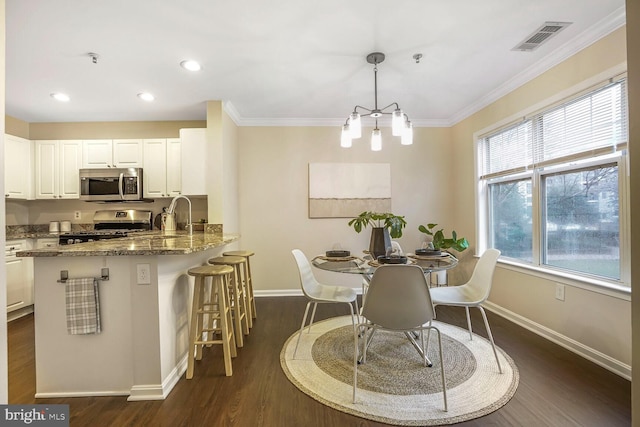 dining room with visible vents, crown molding, baseboards, and dark wood-style flooring