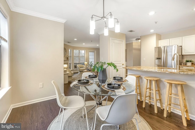 dining space with recessed lighting, dark wood-style floors, baseboards, and ornamental molding