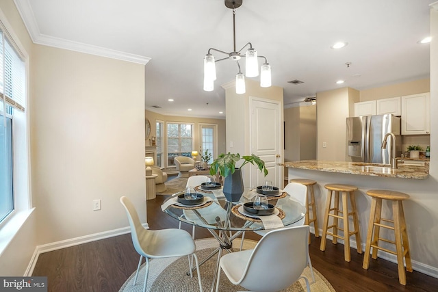 dining room with dark wood finished floors, baseboards, and ornamental molding