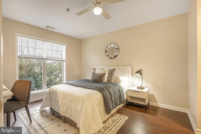 bedroom featuring ceiling fan, visible vents, baseboards, and wood finished floors