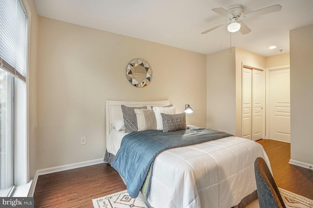 bedroom featuring ceiling fan, a closet, baseboards, and wood finished floors