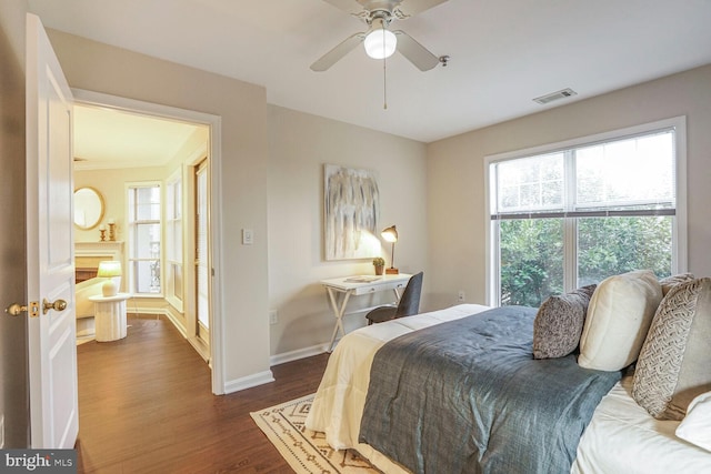 bedroom with visible vents, baseboards, dark wood-type flooring, and a ceiling fan