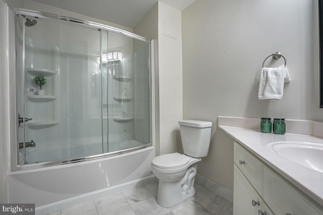 bathroom with vanity, toilet, marble finish floor, and shower / bath combination with glass door