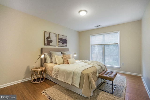 bedroom with visible vents, dark wood-type flooring, and baseboards