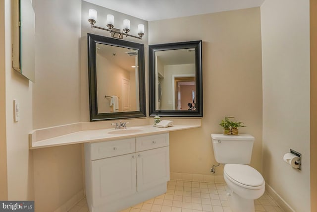 bathroom with vanity, tile patterned floors, toilet, and baseboards