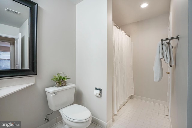 bathroom featuring visible vents, baseboards, toilet, a shower with curtain, and tile patterned floors