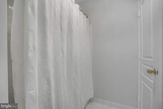 full bath featuring tile patterned floors and baseboards